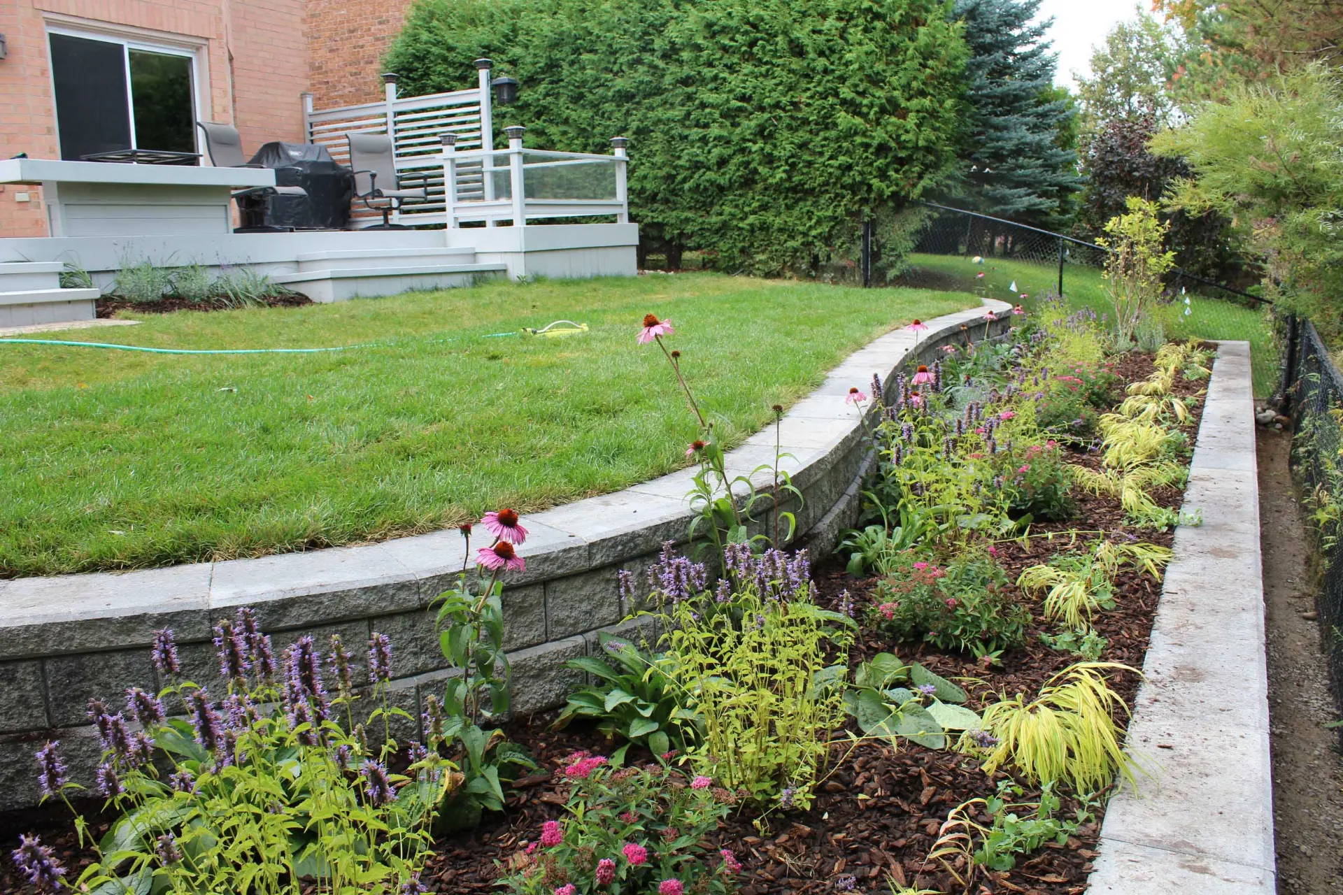 Oaks Ortana wall retaining a planted backyard border